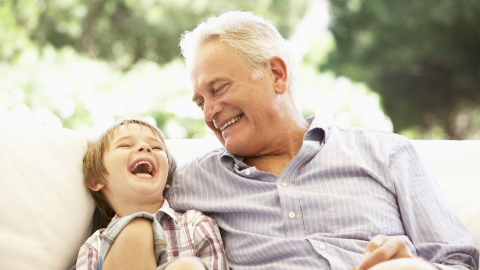 Rentner und Kind beim Lachen Rentner und Kind lachen gemeinsam auf der Couch